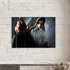 A rectangular wall art print showing a hooded wizard with a long gray beard pointing forward, mounted on a white brick wall above a mantel.
