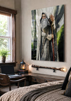 A large vertical wall art print depicting an elderly wizard with a long white beard and staff, shown hanging on a wall in a rustic bedroom setting with a bed, desk, window, and lantern.